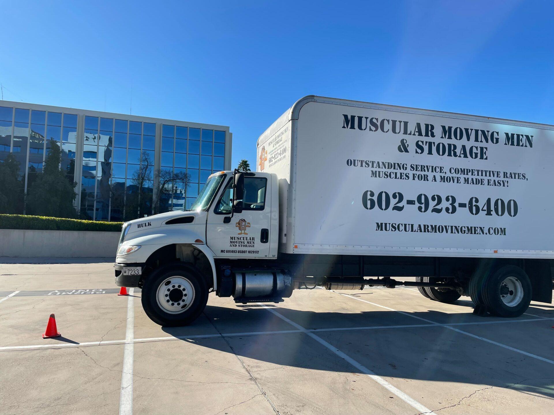 muscular moving men truck sits outside of a corporate office